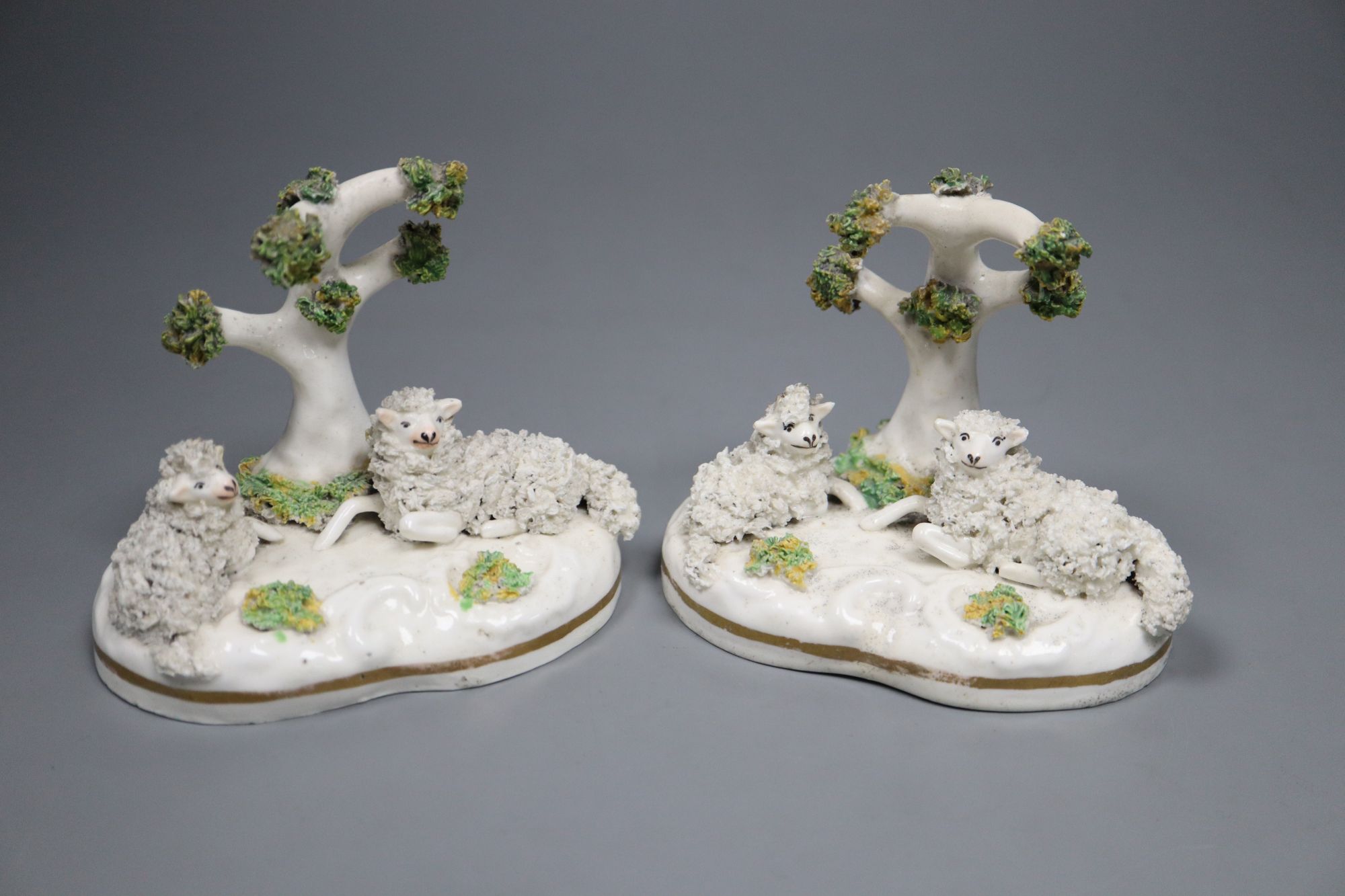 Two similar Staffordshire porcelain models of sheep recumbent beneath a tree, c.1835-50, possibly Lloyd Shelton, 9cm high